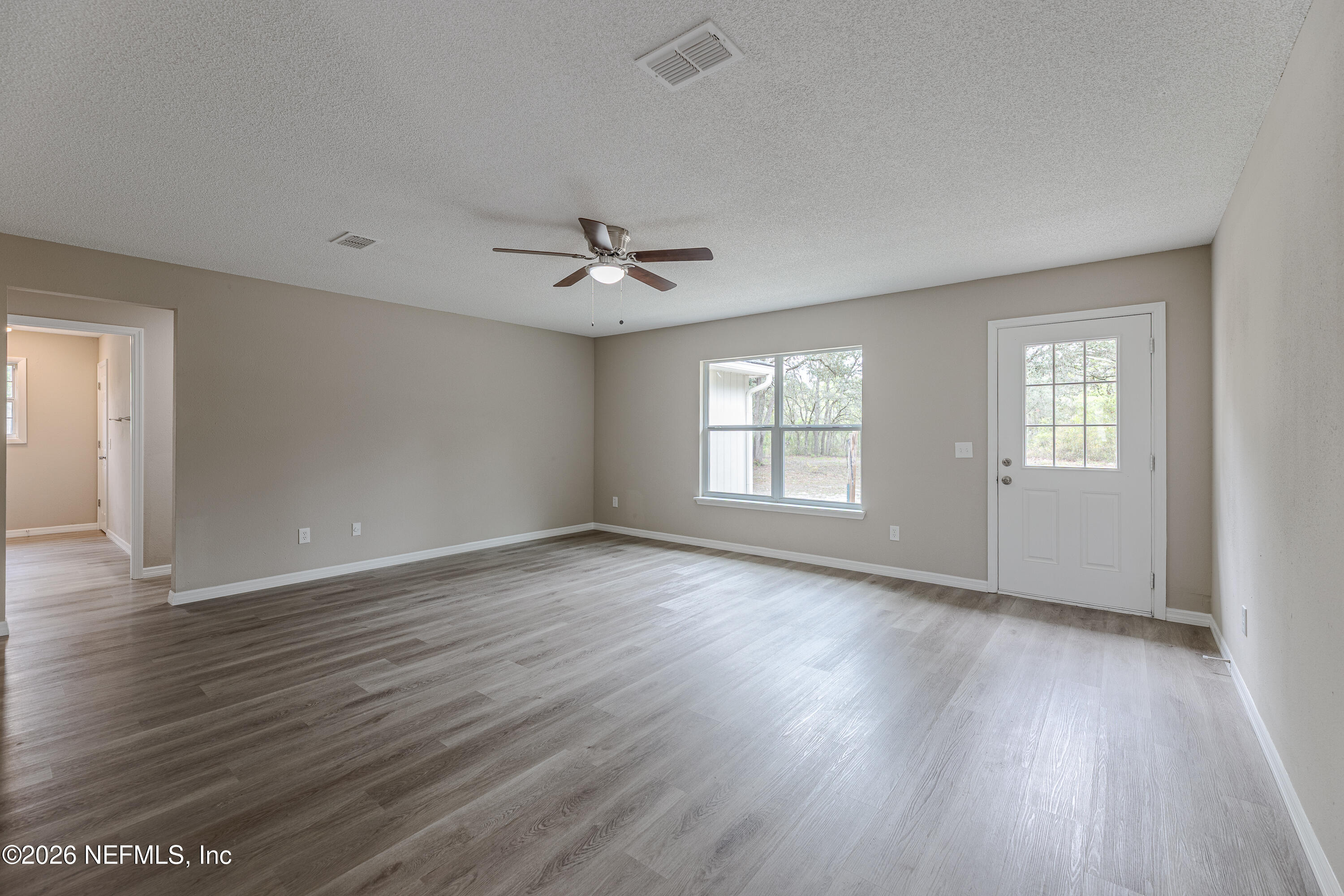 67104 Elnora Lane Yulee, FL 32097 - Photo 25 of 39 a view of an empty room with wooden floor and a window