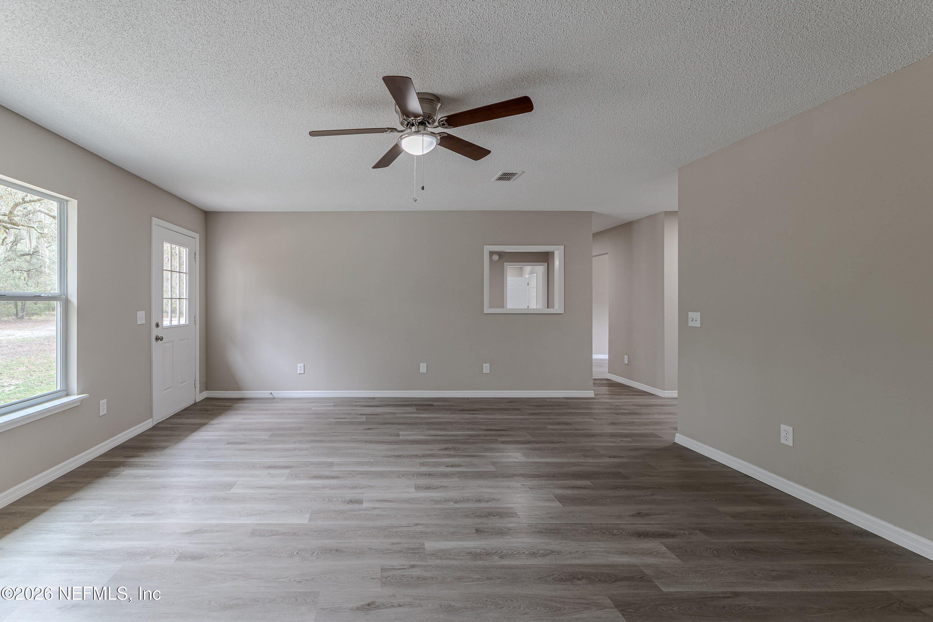 67104 Elnora Lane Yulee, FL 32097 - Photo 28 of 39 a view of an empty room with a window and wooden floor
