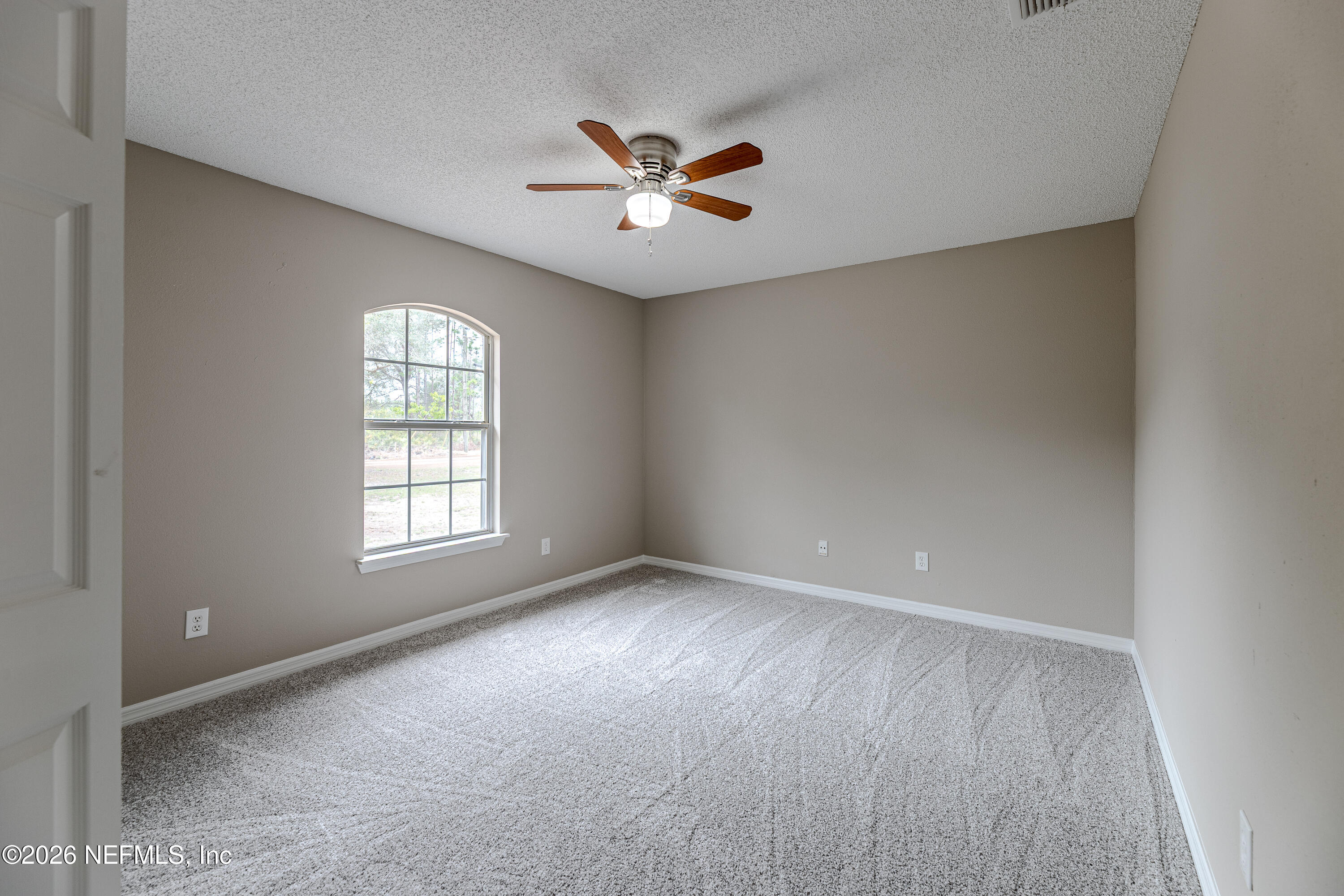 67104 Elnora Lane Yulee, FL 32097 - Photo 32 of 39 an empty room with windows and fan