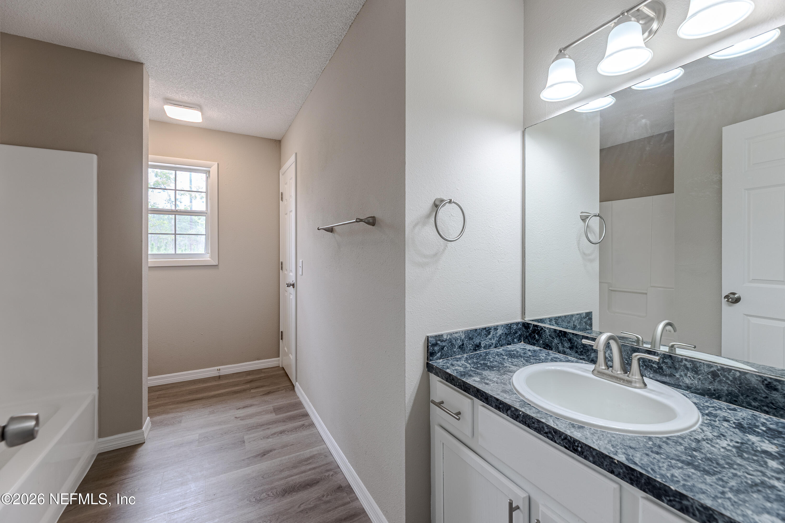 67104 Elnora Lane Yulee, FL 32097 - Photo 34 of 39 a bathroom with a granite countertop double vanity sink and a mirror