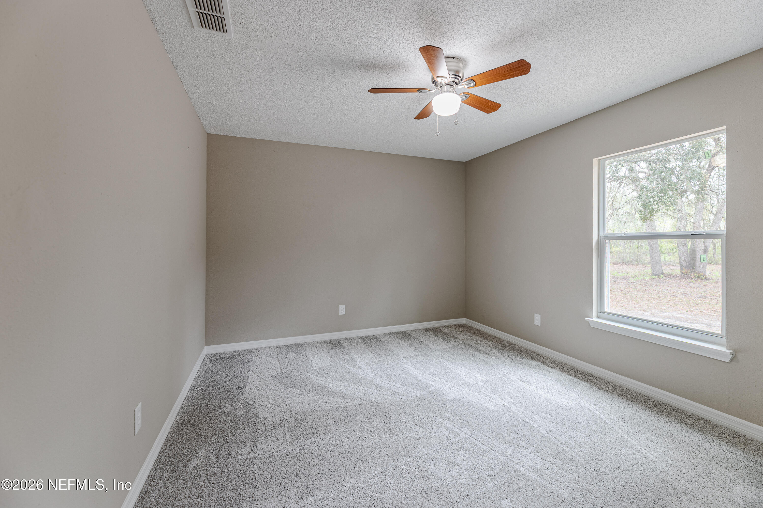 67104 Elnora Lane Yulee, FL 32097 - Photo 38 of 39 an empty room with ceiling fan and windows