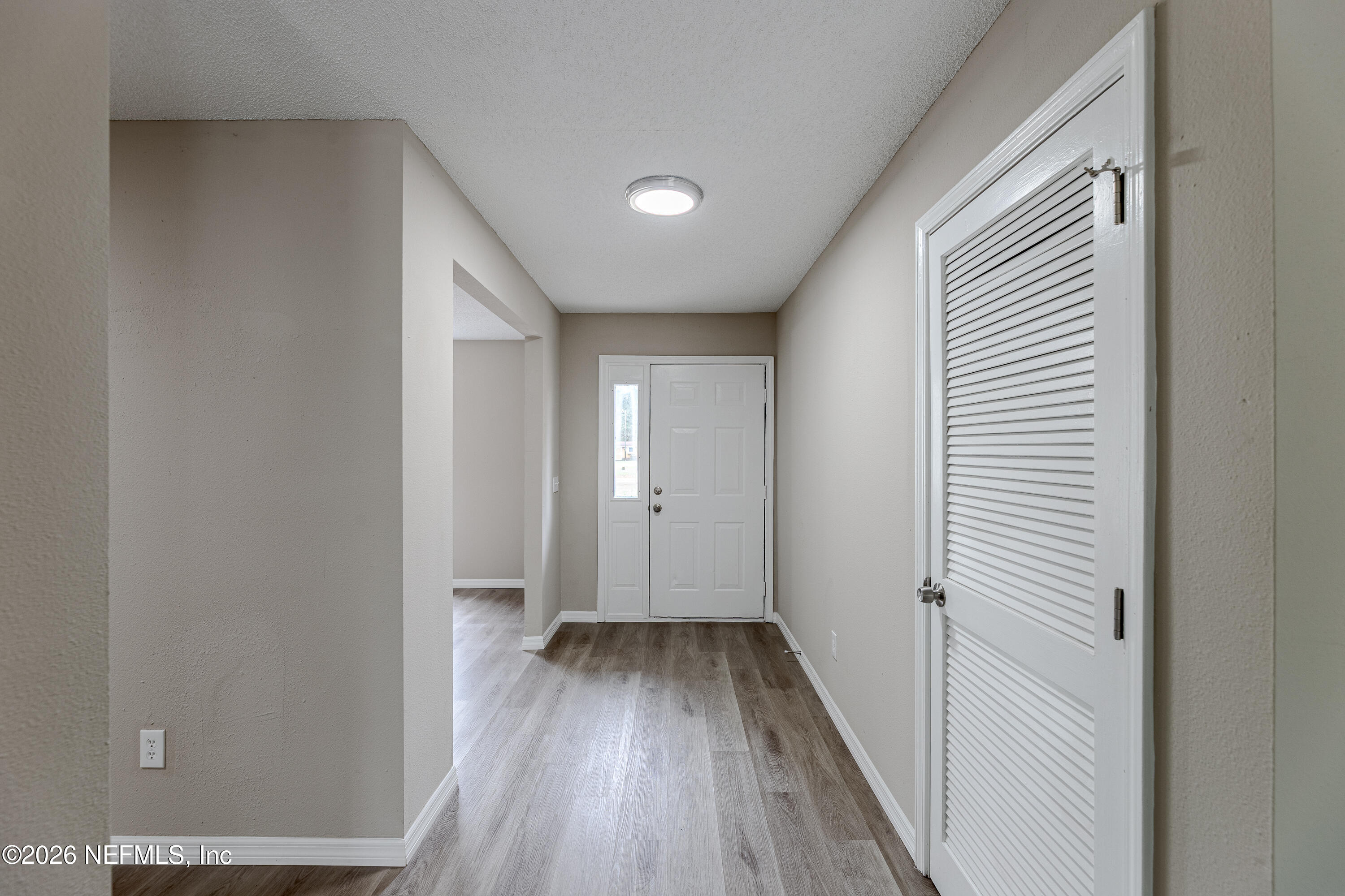 67104 Elnora Lane Yulee, FL 32097 - Photo 8 of 39 a view of a hallway with wooden floor and a bathroom