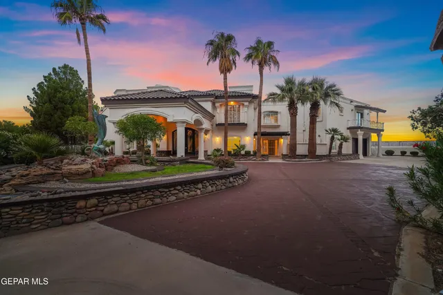 a large white kitchen with kitchen island a large counter top and stainless steel appliances