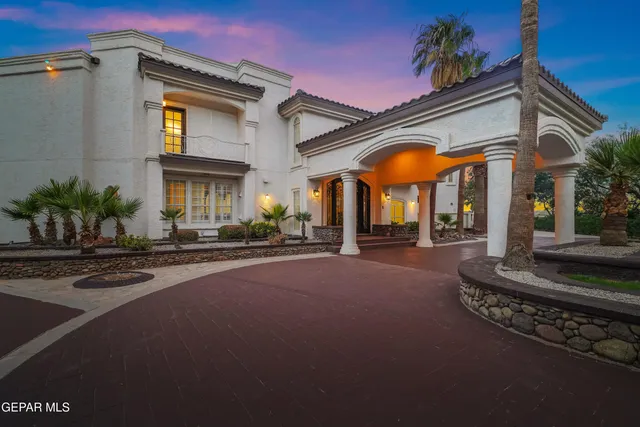 an empty room with chandelier fan and windows
