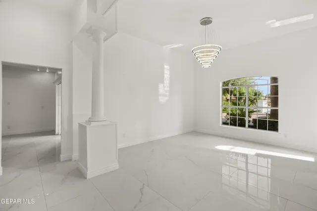 an empty room with windows and ceiling fan