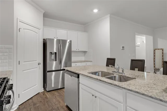 a kitchen with stainless steel appliances granite countertop a refrigerator and a sink