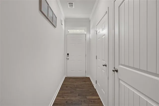 a view of a hallway with wooden floor and closet
