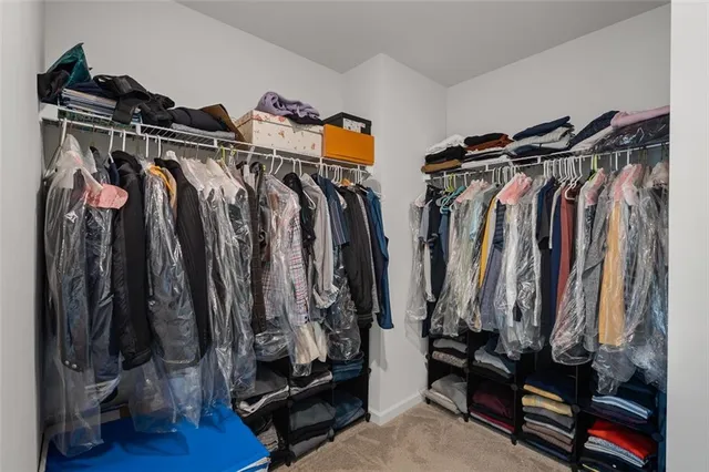 a view of walk in closet with clothes