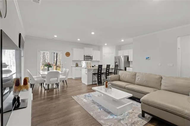 a living room with lots of furniture and view of kitchen