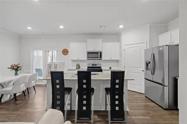 a kitchen with refrigerator and chairs