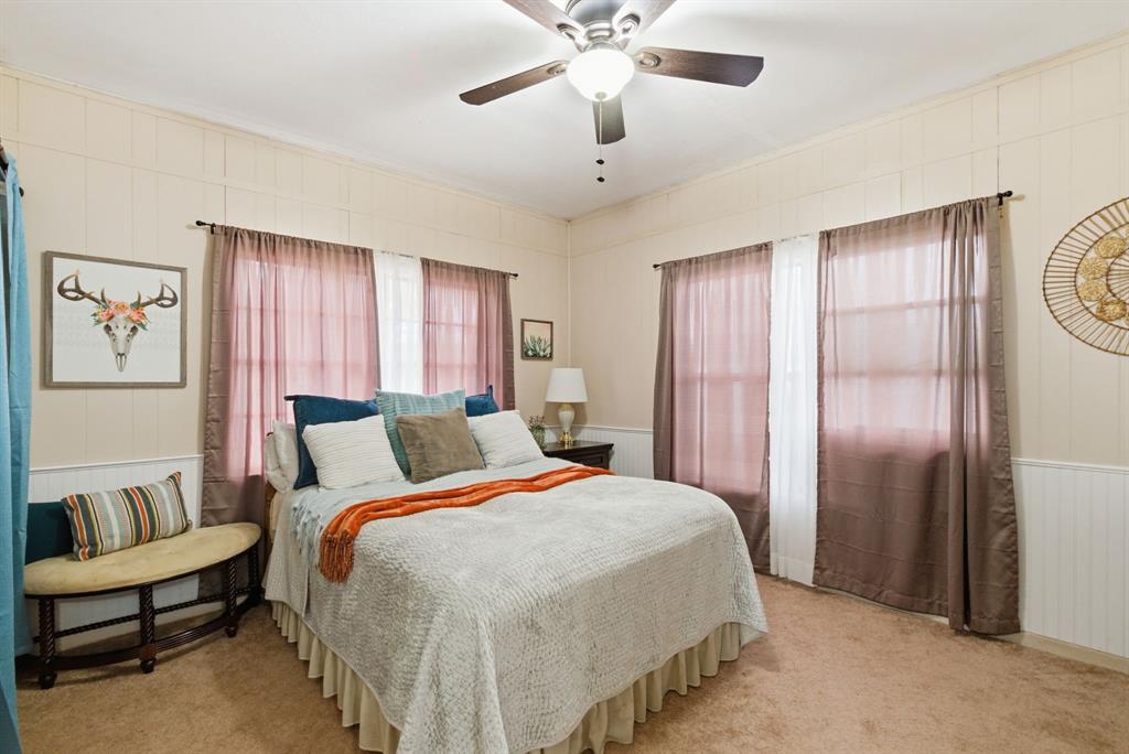 902 North Travis Street De Leon, TX 76444 - Photo 15 of 34 a bedroom with a large bed and a chandelier