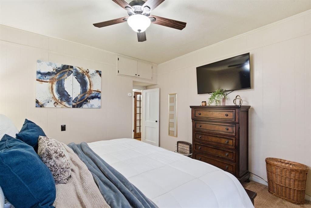 902 North Travis Street De Leon, TX 76444 - Photo 22 of 34 a bedroom with a bed and a flat screen tv