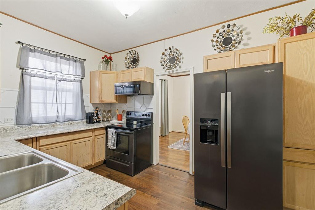 902 North Travis Street De Leon, TX 76444 - Photo 26 of 34 a kitchen with granite countertop a refrigerator and a sink
