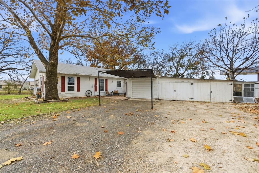 902 North Travis Street De Leon, TX 76444 - Photo 5 of 34 a yard with a large tree
