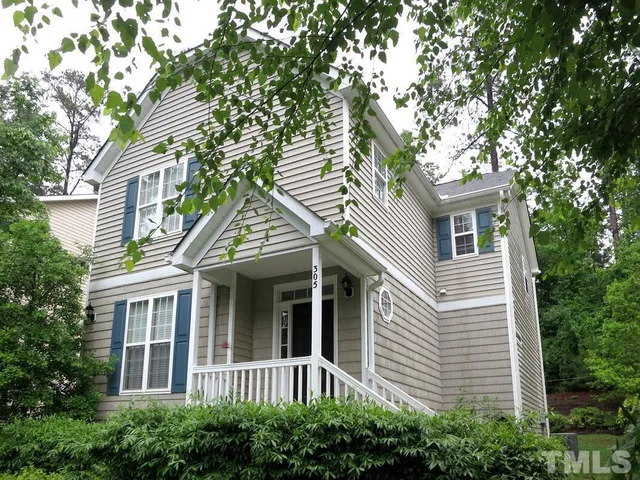 a view of a white house next to a yard