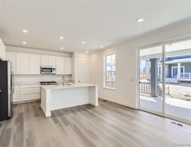 a kitchen with white cabinets and appliances