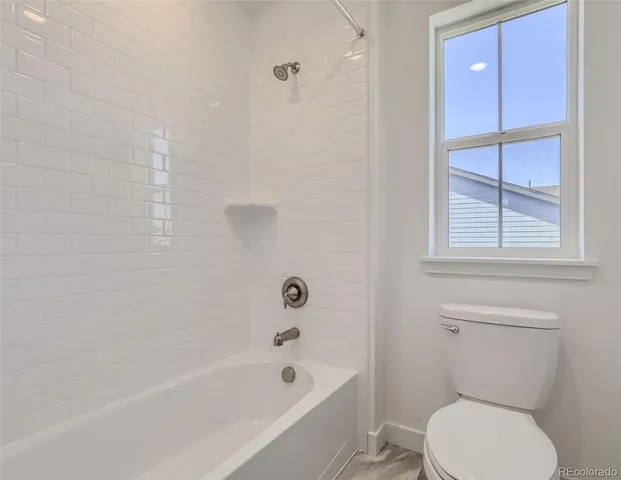 a white toilet sitting next to a bath tub