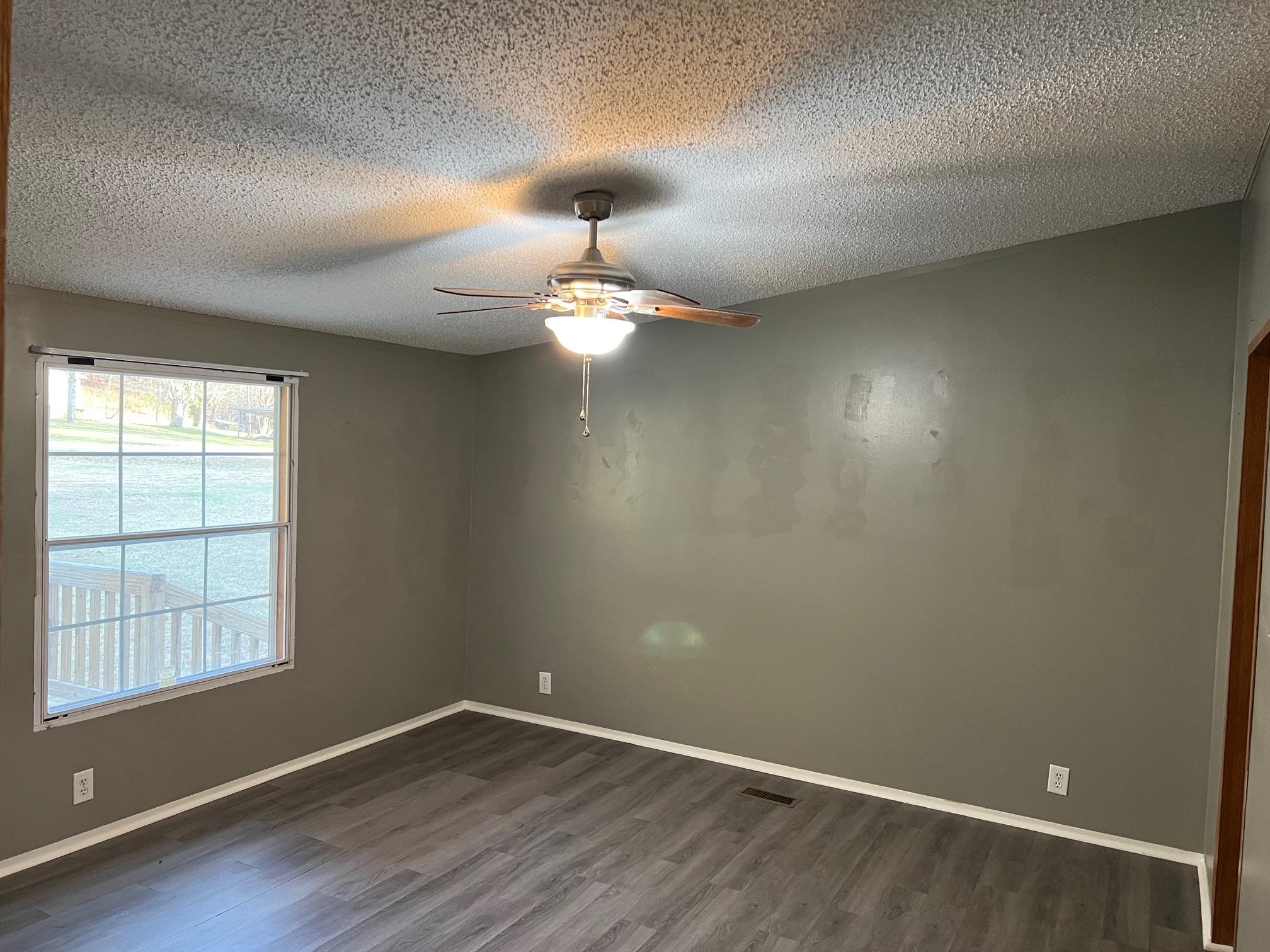 2274 Culps Bend Road Clifton, TN 38425 - Photo 7 of 22 an empty room with wooden floor chandelier and window