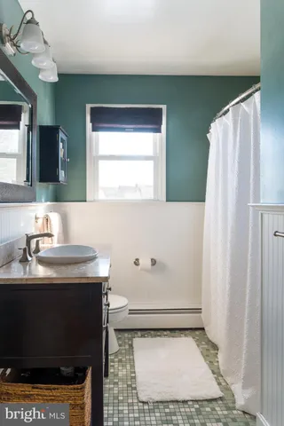 a bathroom with a sink a toilet and a mirror