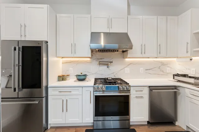 a kitchen with stainless steel appliances a stove a sink and a refrigerator