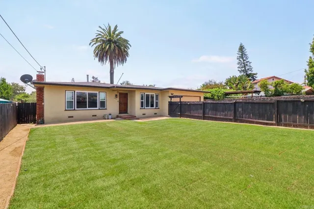 a view of a house with a backyard and a tree