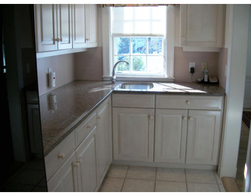 25 Audubon Road Wellesley, MA 02481 - Photo 6 of 15 a kitchen with white cabinets and a window