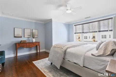 a bedroom with a bed and wooden floor