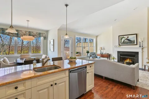 a open kitchen with granite countertop a sink a counter top space and living room view