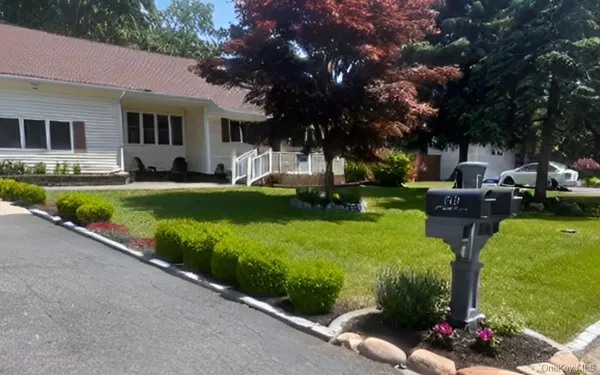 a front view of a house with garden and sitting area