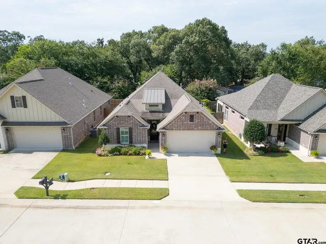 a aerial view of a house with swimming pool and trees in the background