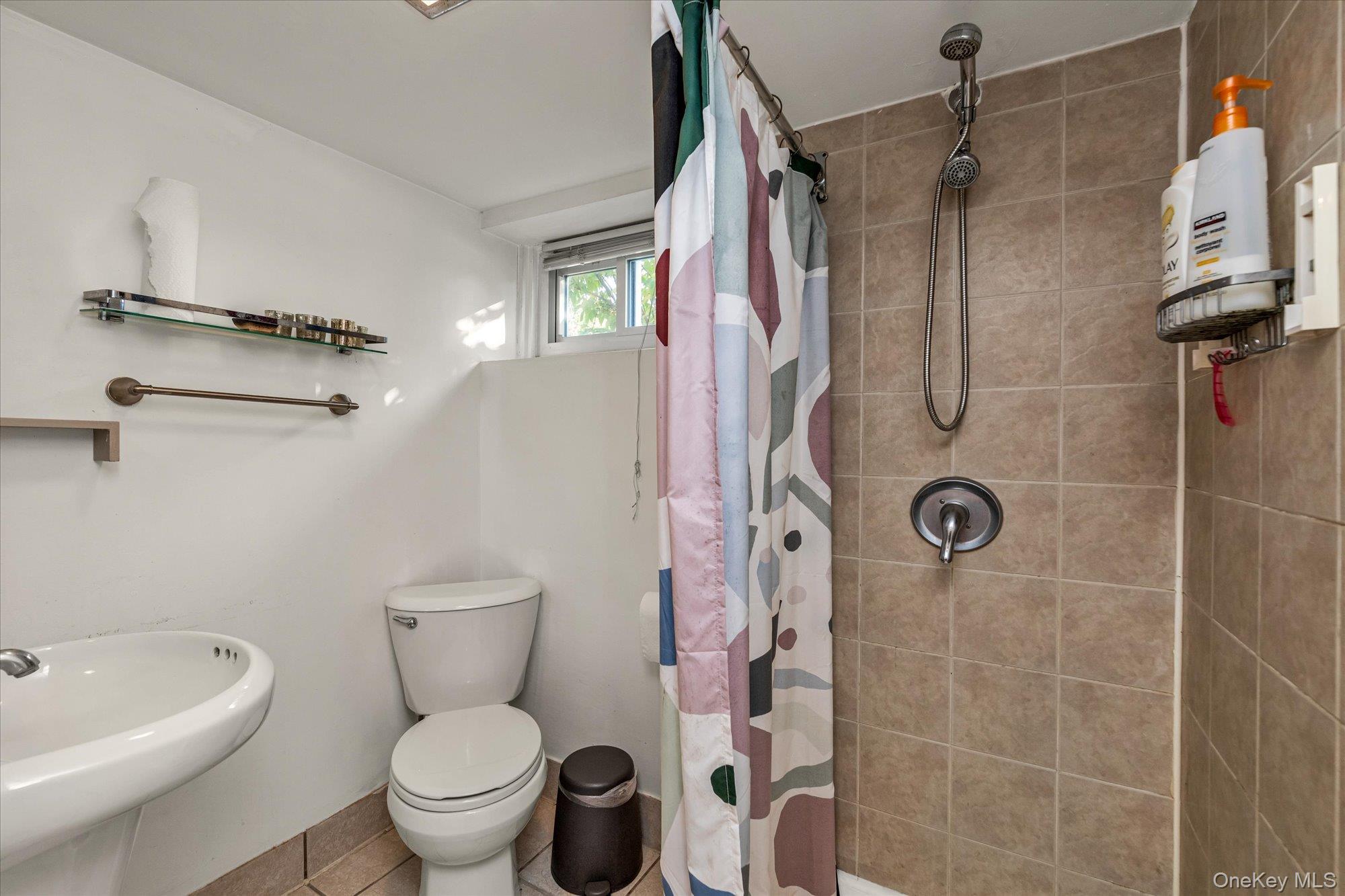 13 Gotham Street Valley Stream, NY 11581 - Photo 15 of 22 a white toilet sitting next to a bathroom sink and a shower