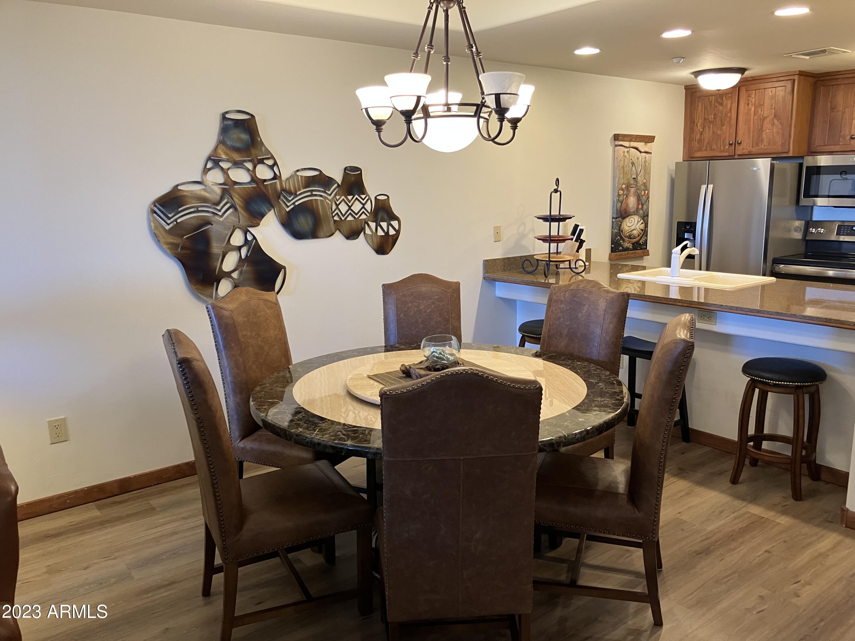 36601 North Mule Train Road, Unit 29C Carefree, AZ 85377 - Photo 3 of 35 a dining room with furniture a chandelier and wooden floor