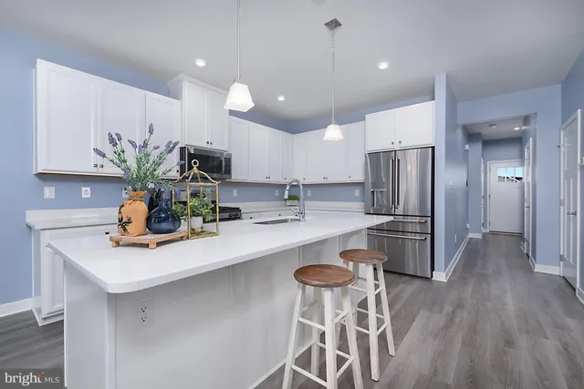 a kitchen with appliances a sink and cabinets