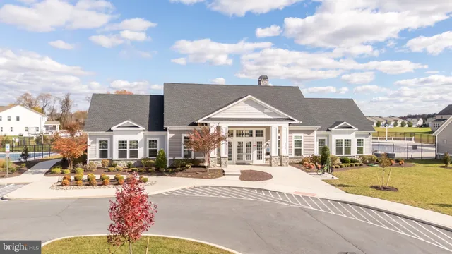 a view of a white house with swimming pool and sitting area
