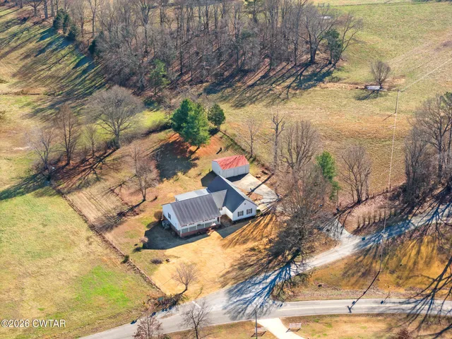 a view of backyard with small cabin and wooden fencing