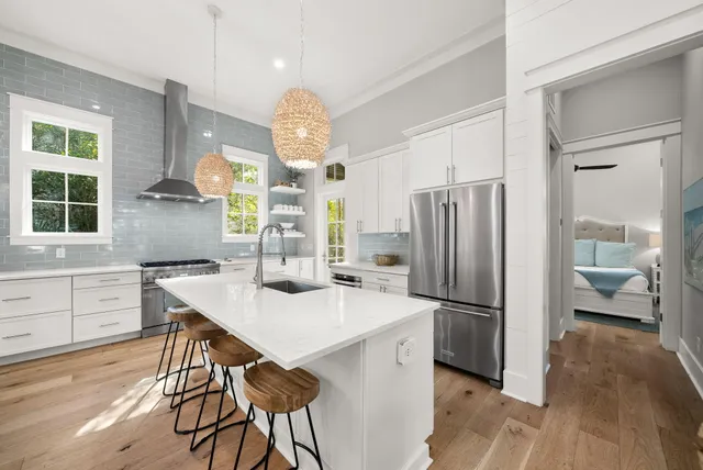 a large kitchen with kitchen island a large counter top space a sink stainless steel appliances and cabinets