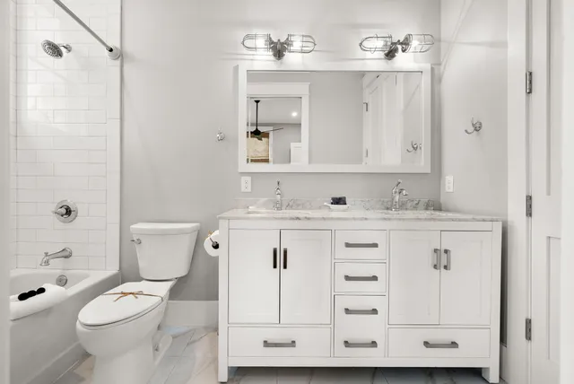 a bathroom with a granite countertop sink a toilet and a mirror