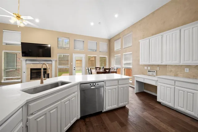 a kitchen with a sink dishwasher a stove and a oven with wooden floor