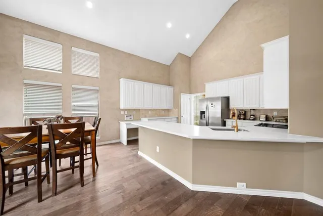 a kitchen with stainless steel appliances a dining table chairs and wooden floor