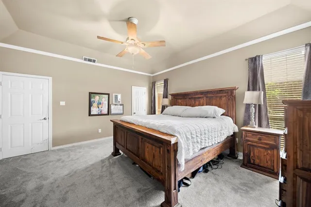 a spacious bedroom with a bed and a chandelier