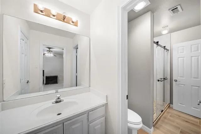 a bathroom with a sink a toilet and shower