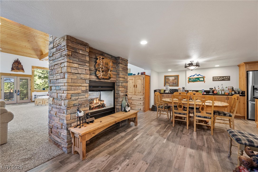 274 Ski Trail Road Mount Charleston, NV 89124 - Photo 6 of 75 Inside, the light-filled great room boasts floor-to-ceiling windows, a dramatic cathedral ceiling, exposed beams, warm woodwork + a two-way fireplace.