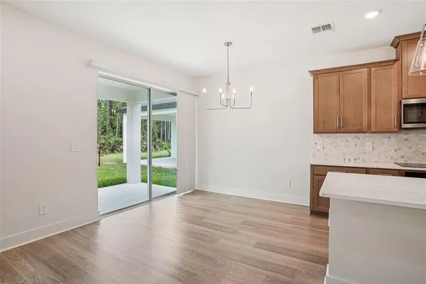 a view of a kitchen with wooden floor and a window