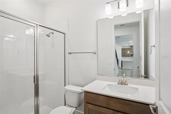 a bathroom with a sink toilet vanity and shower