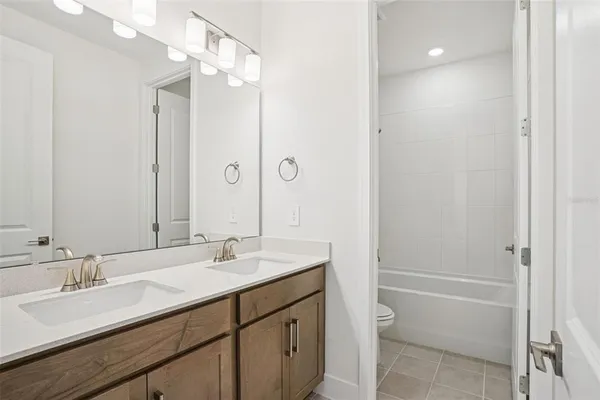 a bathroom with a granite countertop sink a toilet and shower