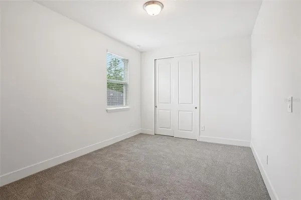 an empty room with windows and closet