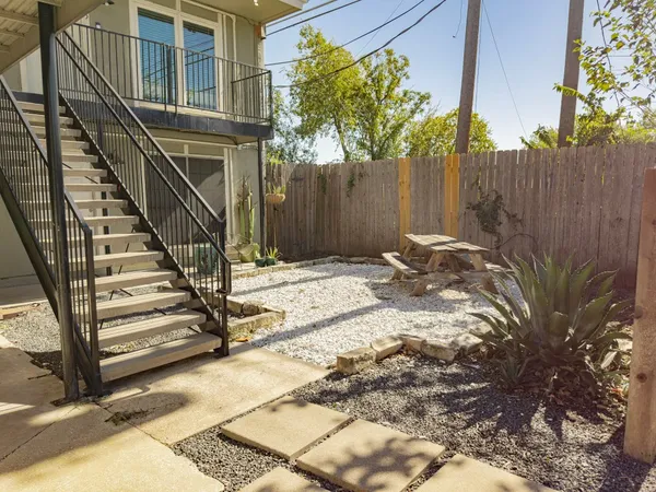 a backyard of a house with lots of green space and wooden fence
