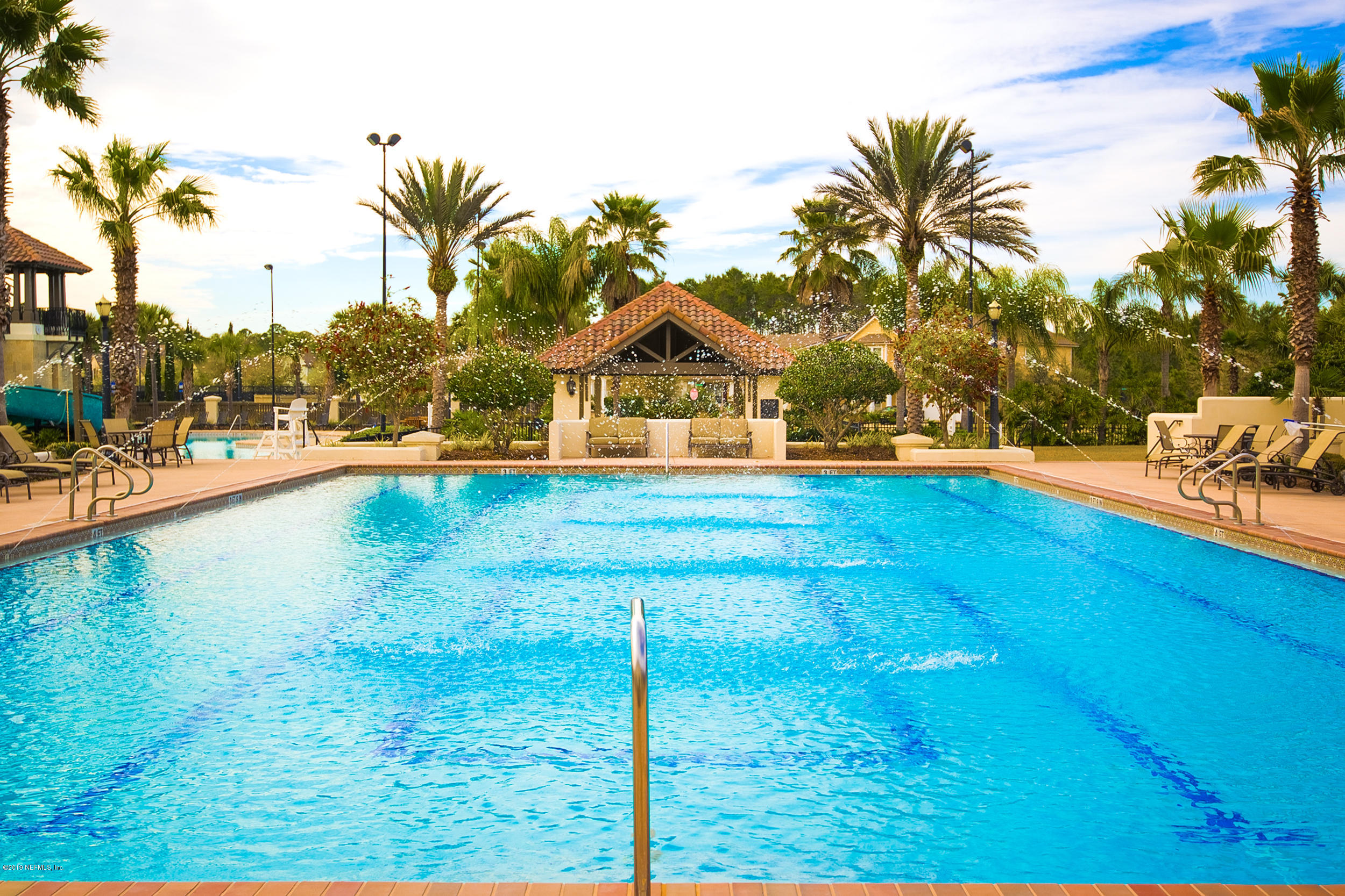800 Riley Lane St. Augustine, FL 32095 - Photo 85 of 88 a view of a swimming pool with a lawn chairs under palm trees
