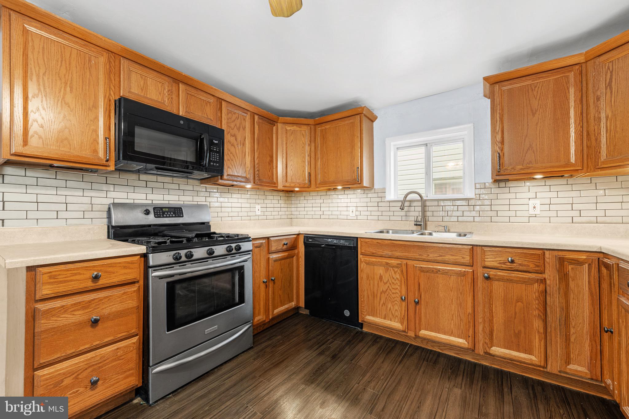 578 Swain Street Bristol, PA 19007 - Photo 6 of 17 a kitchen with stainless steel appliances granite countertop wooden cabinets stove top oven and sink