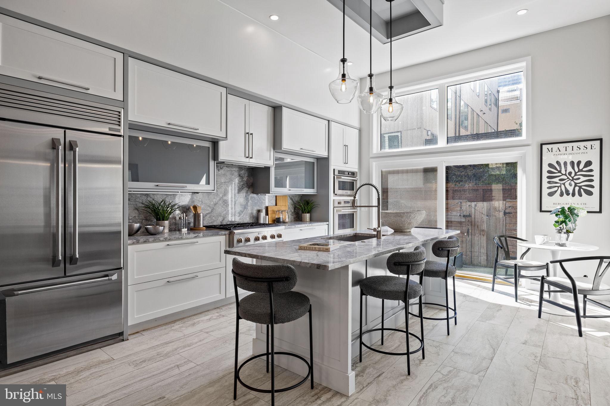 2106 Spring Street Philadelphia, PA 19103 - Photo 15 of 68 a kitchen with stainless steel appliances a dining table chairs stove and refrigerator